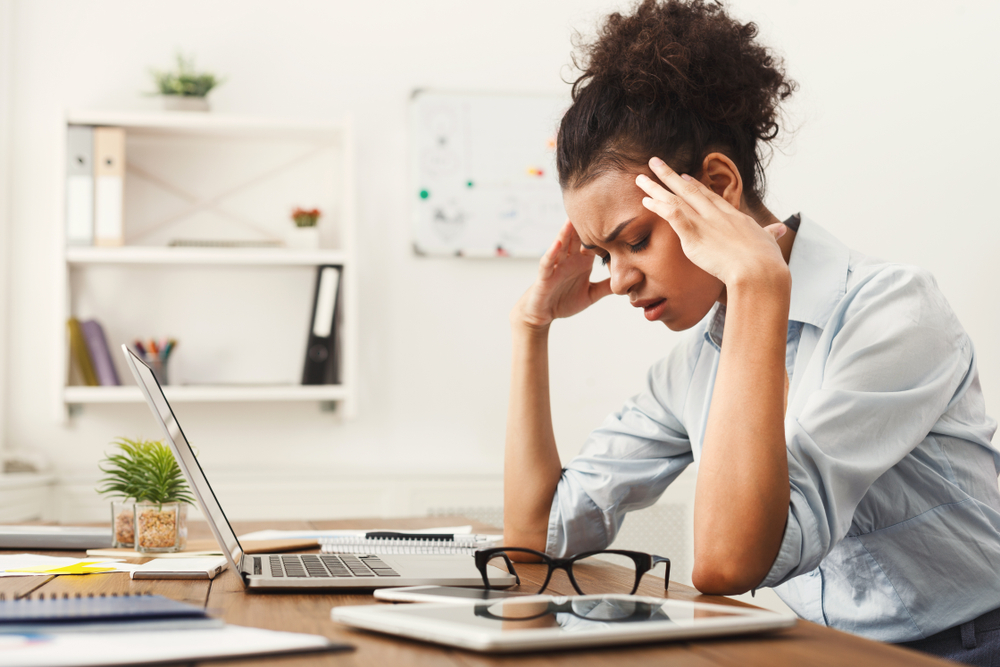 Woman with head in hands — somatic accumulation and stress in the body
